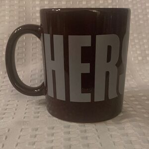 Hershey’s brown mug with the Hershey name printed around it. 4 inches tall.
